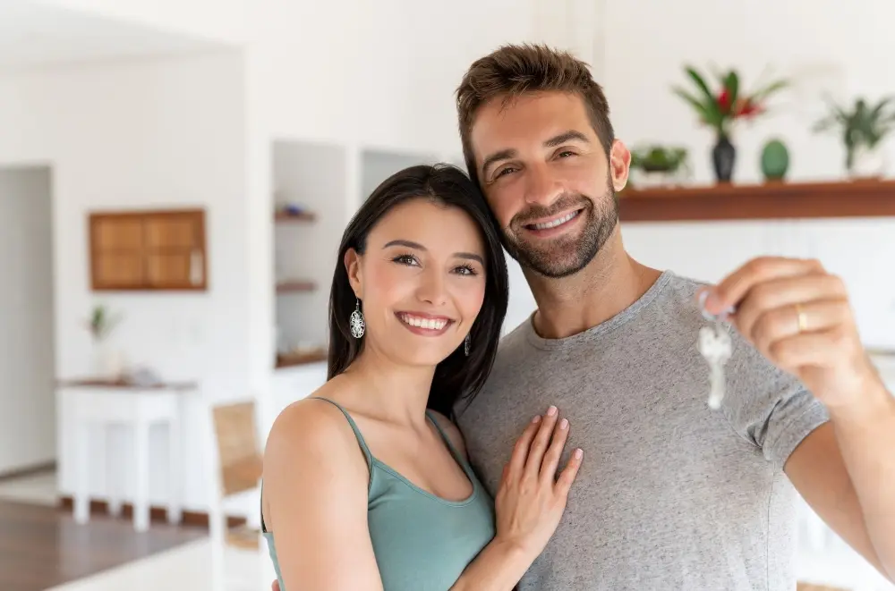 A couple holding up keys to a new home